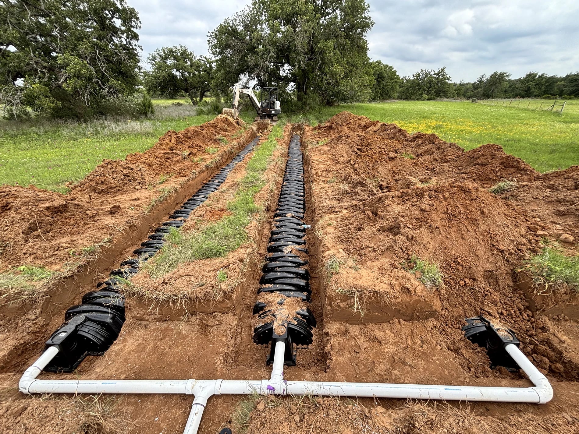 White distribution pipe connected to rows of drainfield chambers