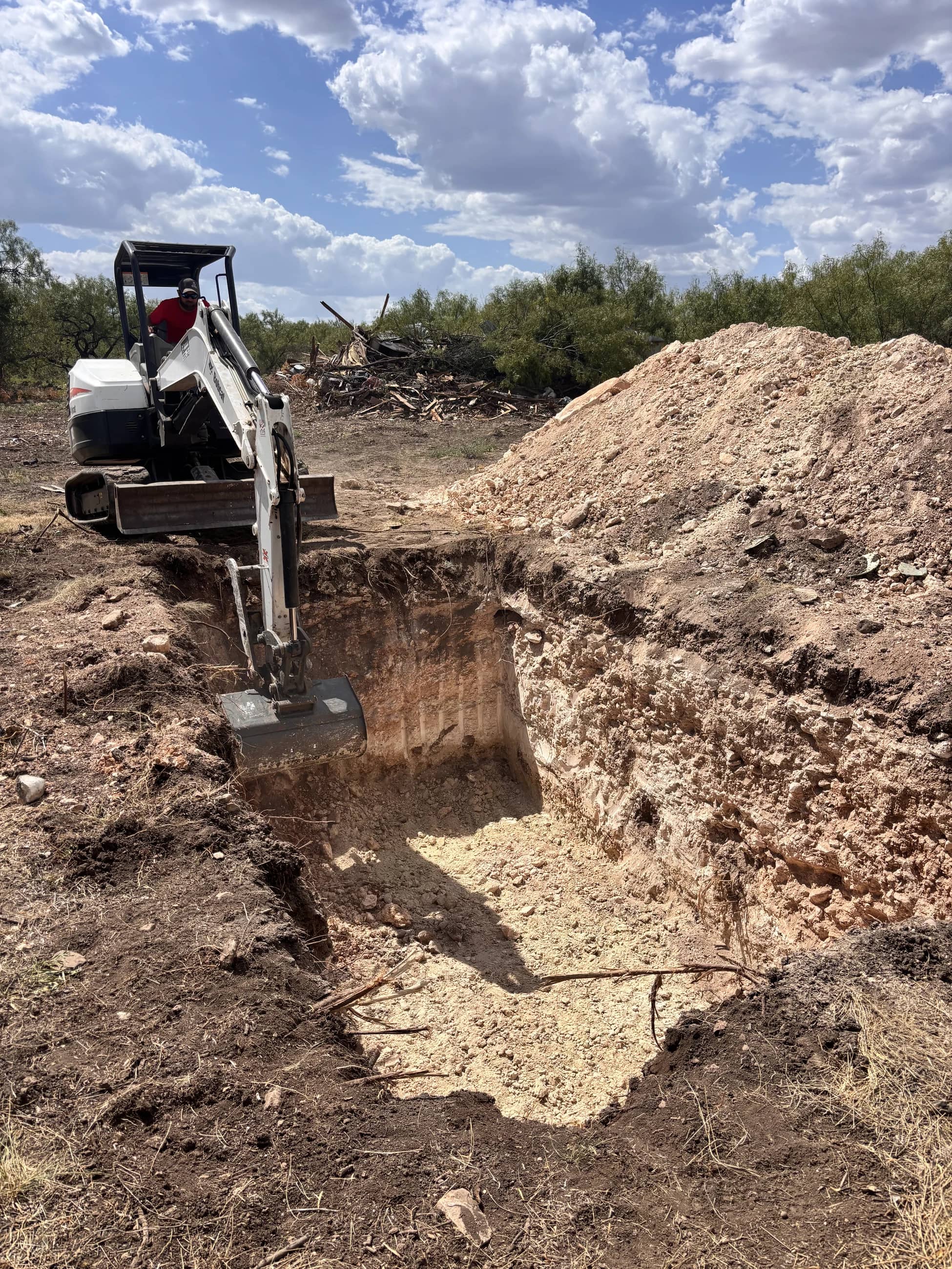Broyles Septic excavator operator digging a tank hole