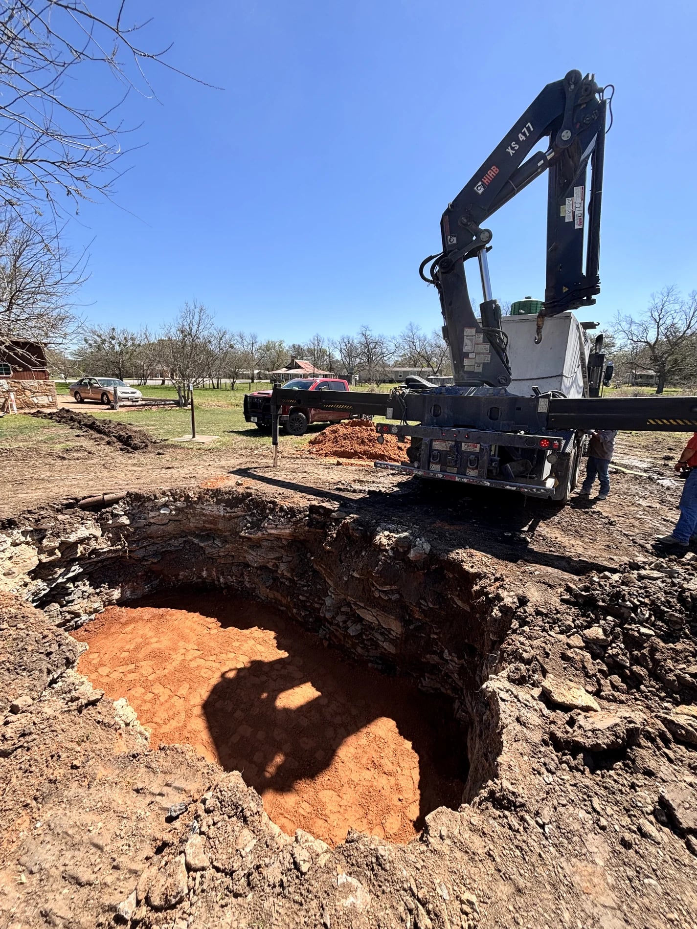 Deep excavated tank pit with crane equipment at the jobsite